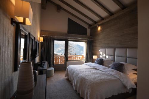 a bedroom with a bed and a large window at No 14 Verbier in Verbier