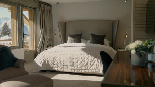 a bedroom with a white bed and a large window at No 14 Verbier in Verbier