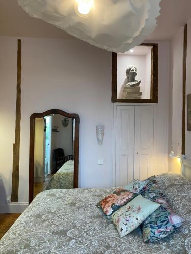 ein Schlafzimmer mit einem Bett mit einem Spiegel und einem Bett mit einem sidx sidx sidx in der Unterkunft Domaine de la Besse in Célon