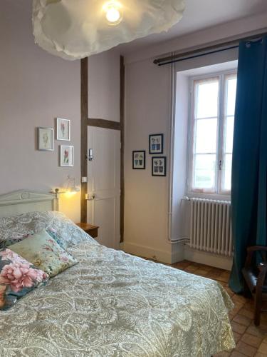 ein Schlafzimmer mit einem Bett und einem großen Fenster in der Unterkunft Domaine de la Besse in Célon