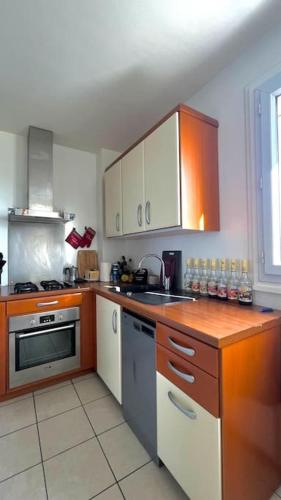 une cuisine avec des armoires en bois et un comptoir dans l'établissement Superbe Appartement 2 chambres avec vue sur la mer et la montagne, à Marseille