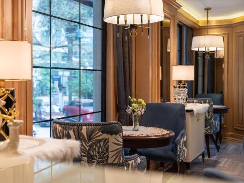 a living room with a table and chairs and a window at Saigon Aroma Hotel in Hanoi