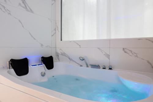 a bath tub with blue water in a bathroom at News ! Loft Movie Station Champagne in Reims