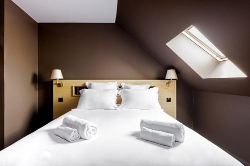 a bedroom with a large white bed with a skylight at Cloître - Entrée autonome, réception en ligne - Encore Mieux in Orléans