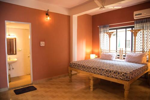 a bedroom with a bed and a window and a sink at Coco Moon Morjim in Morjim