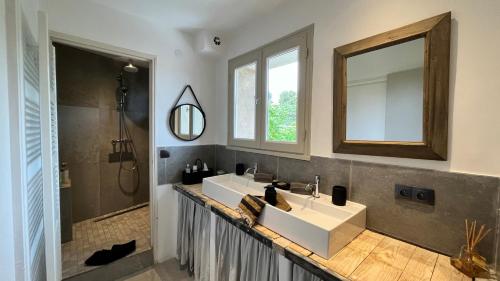 a bathroom with a sink and a mirror at Chambres B&B dans Authentique Mas de Village avec Piscine in Robion en Luberon