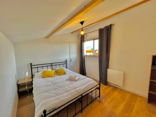 Un dormitorio con una cama con almohadas amarillas. en MAISON LOJE en Saint-Maximin-la-Sainte-Baume