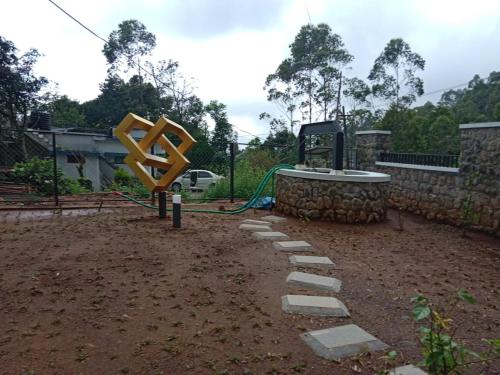 un giardino con una grande scultura gialla e rocce di The Black Stone a Munnar