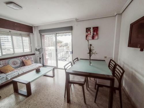 a living room with a table and chairs and a couch at Apartamento sencillo Cerca del mar . in Cullera