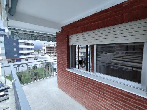 a red brick building with windows on a balcony at Apartamento sencillo Cerca del mar . in Cullera