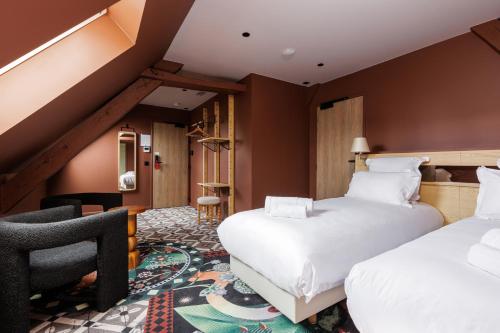 a hotel room with two beds and a chair at La Loge Gogaille - Cloître - Accès autonome in Orléans