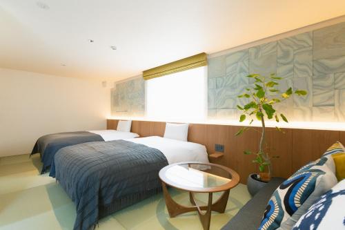 a hotel room with two beds and a window at Nagi Kurashiki Hotel&Lounge in Kurashiki