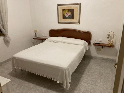 リド・ディ・フォンディにあるcasa Ginevraのベッドルーム1室(壁に絵が描かれた白いベッド1台付)