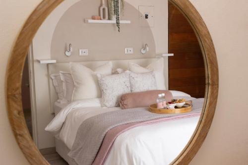 einem Spiegel, der ein Bett in einem Zimmer reflektiert in der Unterkunft Neapolitan Guesthouse in Alberton