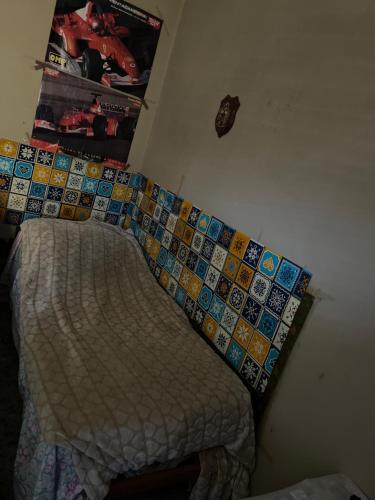 1 dormitorio con cama y pared de azulejos en Albania, en Pompeya