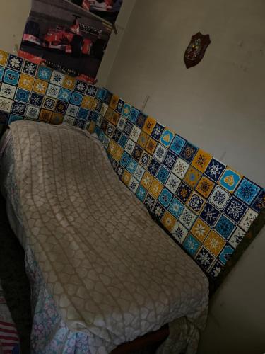 Cama en habitación con pared de azulejos en Albania, en Pompeya