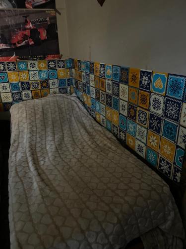 1 cama en una habitación con azulejos en la pared en Albania, en Pompeya