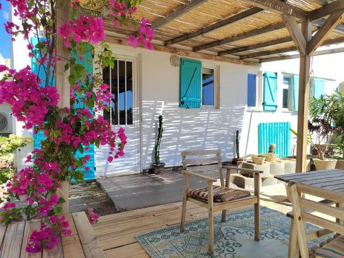 un patio con mesa, sillas y flores en Oneiro glico, en Agia Marina Aegina