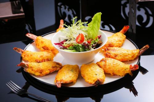 a plate of food with a salad and chicken tenders at Hotel Indigo Xiamen Harbour by IHG in Xiamen