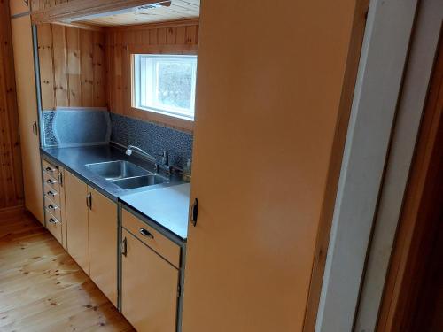 una pequeña cocina con fregadero y ventana en Elanden rust en Edebäck