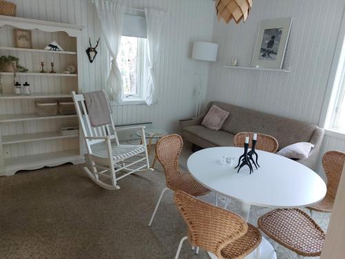 sala de estar con mesa, sillas y sofá en Elanden rust en Edebäck
