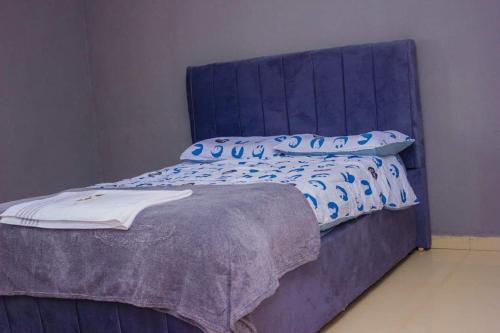 a blue bed with blue pillows on top of it at Itawa Apartments in Ndola