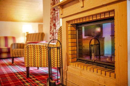 a living room with a fireplace with chairs at Arc 1950, Hameau du Glacier, Dernier étage , 63m2 , 5m de hauteur sous plafond dans le séjour, Cheminée, Balcon Sud, Piscine, ski aux pieds in Bourg-Saint-Maurice