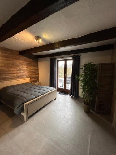 een slaapkamer met een bed en een groot raam bij Gîte La Gernelle in Bouillon
