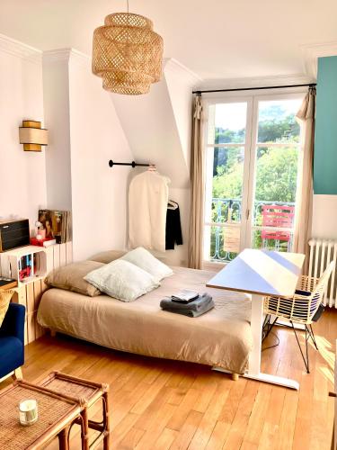 a bedroom with a bed and a table and a window at Amazing Sacre-Coeur views in Montmartre in Paris