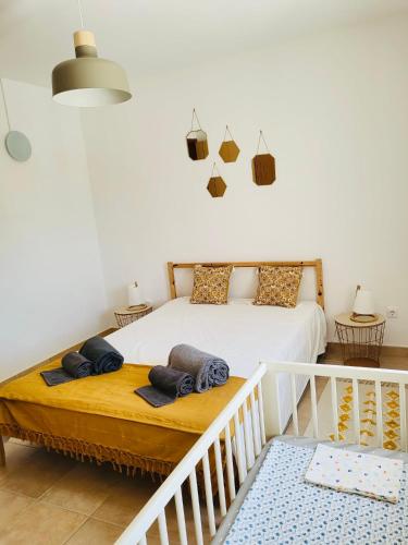 a bedroom with a white bed with two pillows on it at Sand, Water & Sun House in Vila Nova De Cacela
