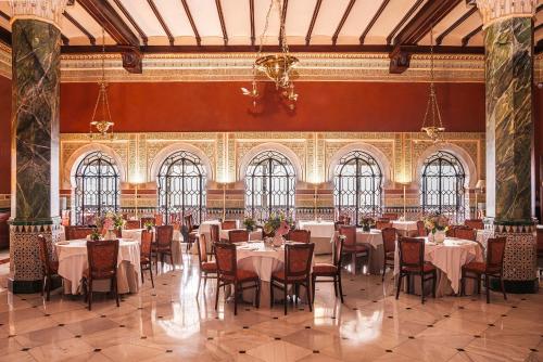 a dining room with tables and chairs in a building at Alhambra Palace Hotel in Granada