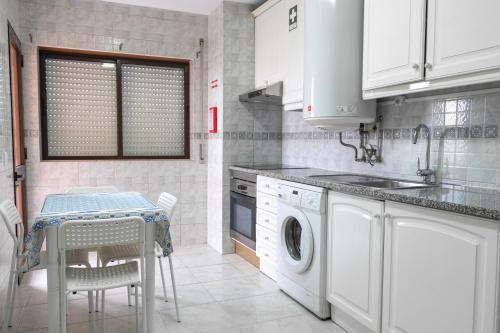 a kitchen with a sink and a washing machine at BLife Ricardya private rooms in Faro