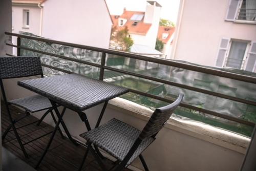 un balcon avec deux chaises et une table sur un balcon dans l'établissement F2 Vaires sur marne, à Vaires-sur-Marne