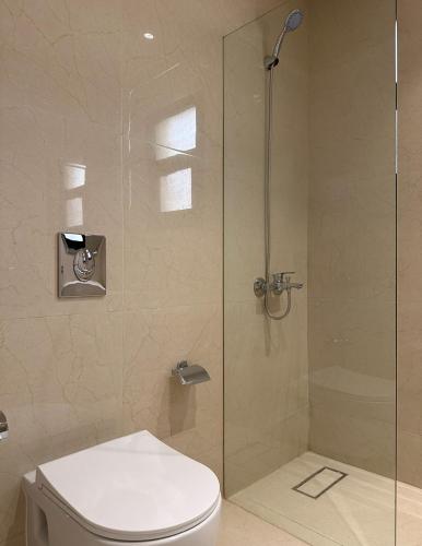 a bathroom with a toilet and a glass shower at fin apartment C6 in Riyadh