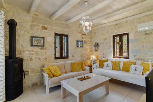 un soggiorno con divano e piano cottura di Villa Clio -St George Retreat BY APOKORONAS VILLAS a Kókkinon Khoríon