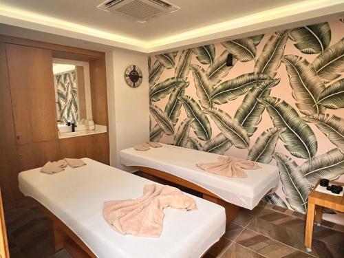 two beds in a room with a palm tree wallpaper at The Best Apartment on the beach 'Caesar Beach' Bogaz, North Cyprus in Boghaz