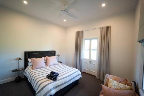 - une chambre avec un lit doté d'oreillers roses et d'une fenêtre dans l'établissement Ravenscroft Cottage, à Eccleston