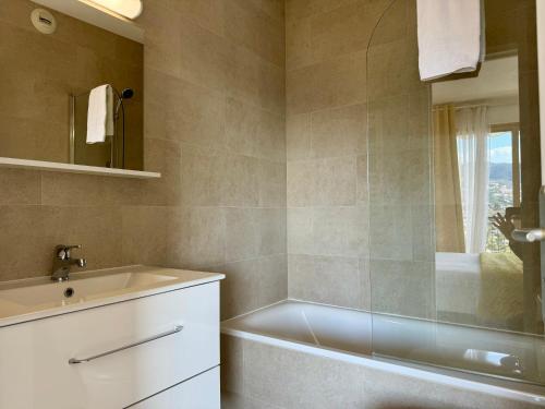 une salle de bain avec une baignoire et un lavabo dans l'établissement My Resid Appart Marina vue magnifique sur la montagne, à Mandelieu-la-Napoule