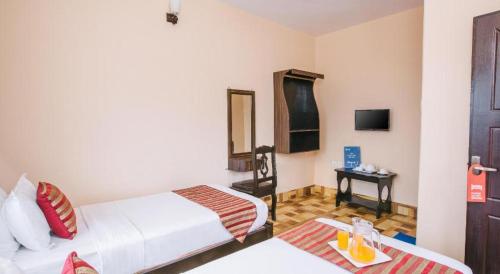 ein Hotelzimmer mit 2 Betten und einem TV in der Unterkunft Hotel Ezen in Pokhara