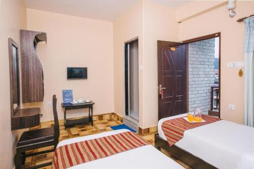 Zimmer mit 2 Betten und einer Tür in der Unterkunft Hotel Ezen in Pokhara