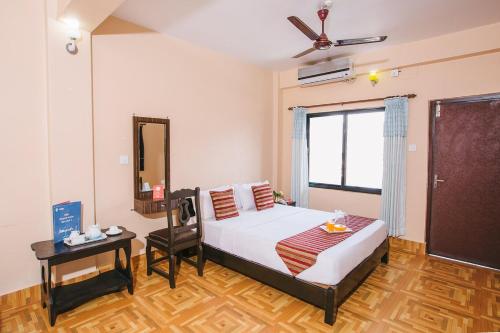 Schlafzimmer mit einem Bett, einem Tisch und einem Spiegel in der Unterkunft Hotel Ezen in Pokhara