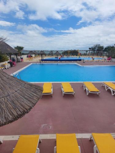 uma piscina com espreguiçadeiras amarelas e um resort em Au lac des rêves em Lattes