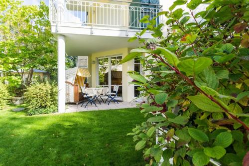 ein Haus mit einem Balkon und einem Garten mit grünem Gras in der Unterkunft Villa Charlotte App.13 in Heringsdorf