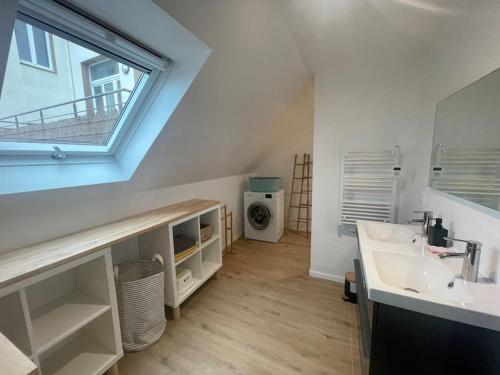 a white bathroom with a sink and a window at Kermorvan - pleine vue mer- parking et wifi - départ pour les îles in Le Conquet
