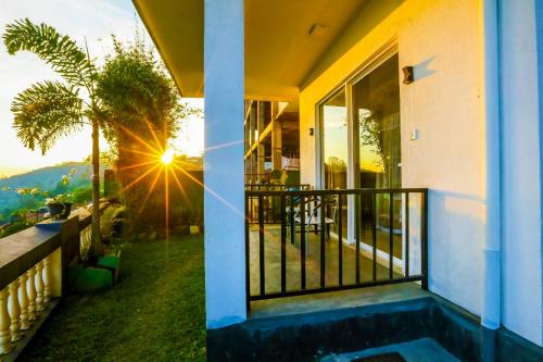 a house with a balcony with a view of the sunset at Srilak View Holiday Inn in Haputale