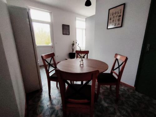 een eetkamer met een tafel en stoelen en een raam bij La ferme des sorciers in Agnez-lès-Duisans