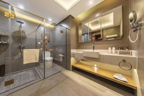 a bathroom with a sink and a shower at Jiangshan Yunfan Sports Resort Hotel in Jiangshan