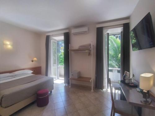 Schlafzimmer mit einem Bett, einem Tisch und einem Schreibtisch in der Unterkunft Hotel Principe Eugenio in Rom