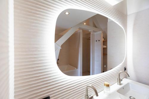 Baño con espejo circular sobre un lavabo en appartement Globo XL, en Middelburg