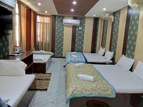 Habitación con 2 camas y escritorio. en Hotel Regard en Varanasi